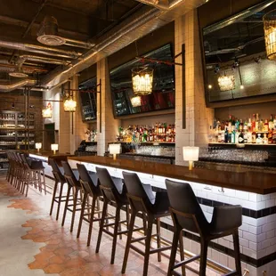 a long bar with a row of bar stools