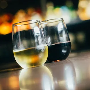two glasses of wine on a bar