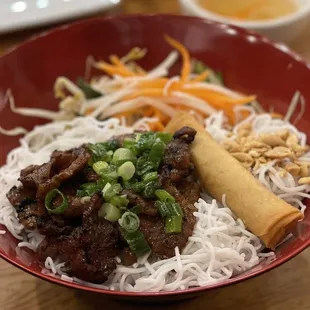 a bowl of noodles with meat and vegetables