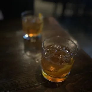 two glasses of whiskey on a table