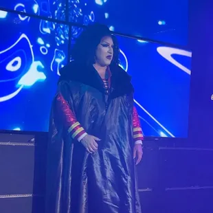 a woman dressed in a black cloak and red cape