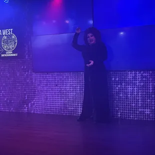 a woman in a black dress on stage