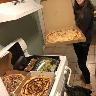 a woman holding a box of pizza