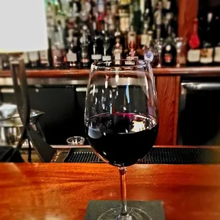 a glass of wine on a bar
