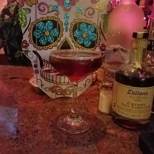a glass of wine and a sugar skull