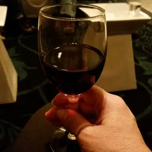 a hand holding a wine glass