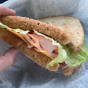 a hand holding a sandwich