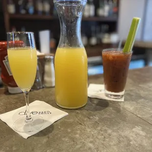 a pitcher of orange juice and two glasses of juice