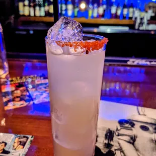 a cocktail with a garnish on the rim