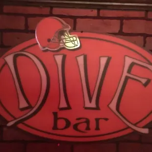 a football helmet on top of a dive bar sign