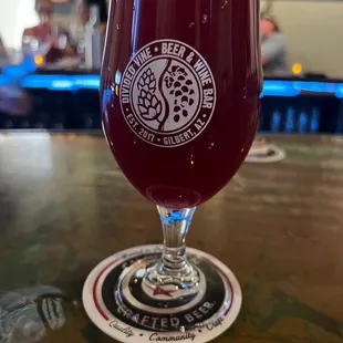 a glass of beer on a bar