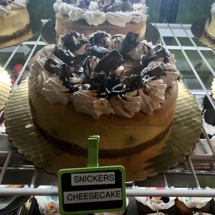 Snickers cheesecake with white frosting.