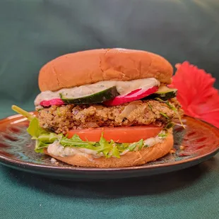 This nutrient-packed seared quinoa burger is topped with organic cucumbers, radish and tomatoe with a cilantro aioli drizzle.