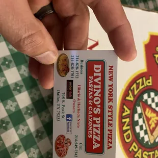 a hand holding a pizza box