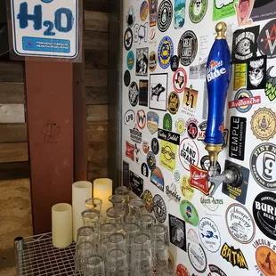 a wall of beer glasses and beer taps