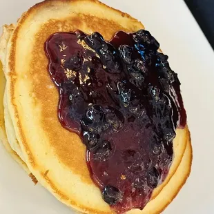 a stack of pancakes with blueberry sauce