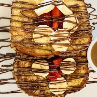 a plate of french toast with strawberries and bananas