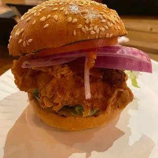 a fried chicken sandwich on a paper plate