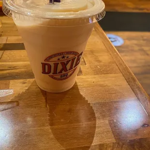 a drink in a plastic cup on a wooden table