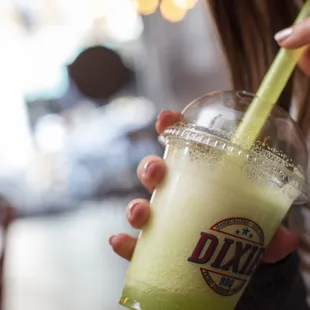 a woman holding a drink in her hand