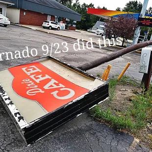 a broken sign on the side of the road