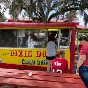 a group of people standing around a food cart