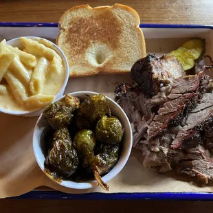 Beef brisket meat platter with Brussel sprouts and mac and cheese.