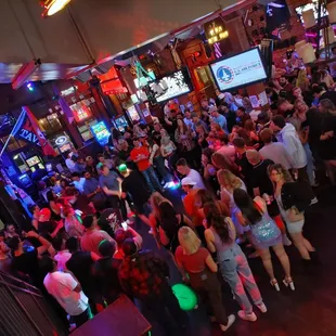 a crowded bar with neon lights