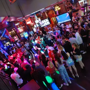 a crowded bar with neon lights