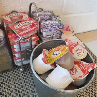 Jellies, apple butter, sugar, and creamers on the table