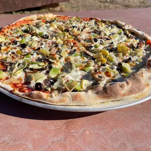 a pizza with olives, artichokes, and cheese