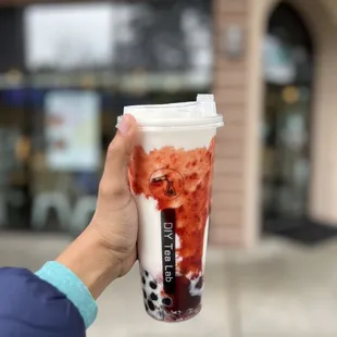 a hand holding a cup of iced tea