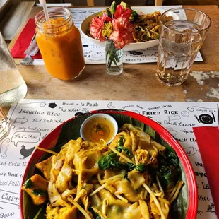 Thai iced tea, Djan&apos;s Fusion Noodle (further), and Pad Flat Noodle with Special Curry (closer)