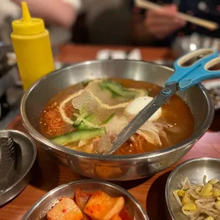 a bowl of soup with a pair of scissors