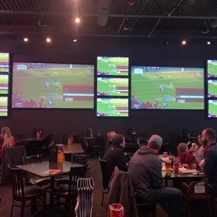a group of people sitting at tables watching a game