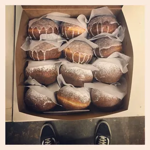 A dozen paczki with various sugars on top.
