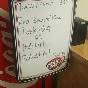 a coca cola machine with a menu on it