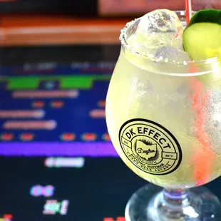 a drink with a cucumber garnish