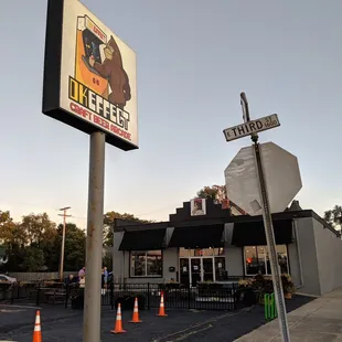 a restaurant with a sign and traffic cones