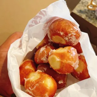 a person holding a bag of doughnuts