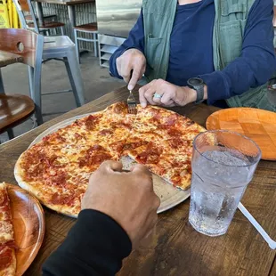 a person cutting a pizza