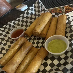 a plate of fried spring rolls with dipping sauce