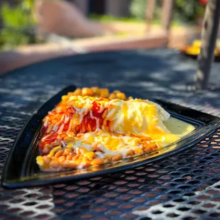 Smothered breakfast burrito - your choice of ham, bacon, or chorizo, eggs, breakfast potatoes, and shredded cheese, green or red chile
