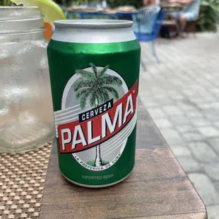 a can of palma next to a glass of water