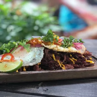 Tostones con Vaca Frita topped with huevos