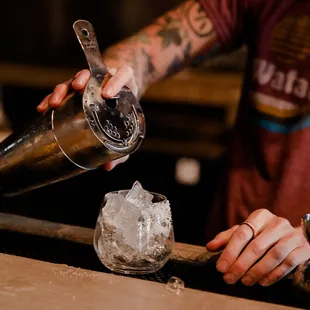 a bartender pouring a drink at a bar