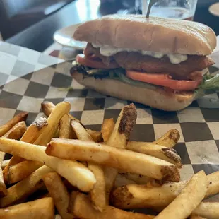 a sandwich and french fries on a checkered paper