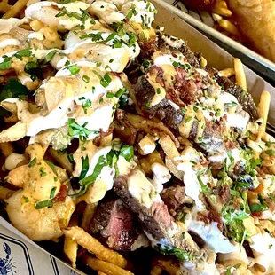 Fries loaded with lobster, grilled steak, and grilled shrimp