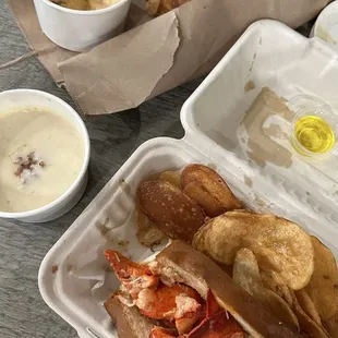 lobster and potato chips in a styrofoam container
