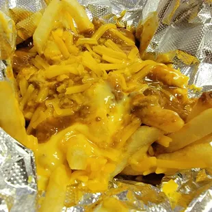 a hot dog covered in cheese and onions